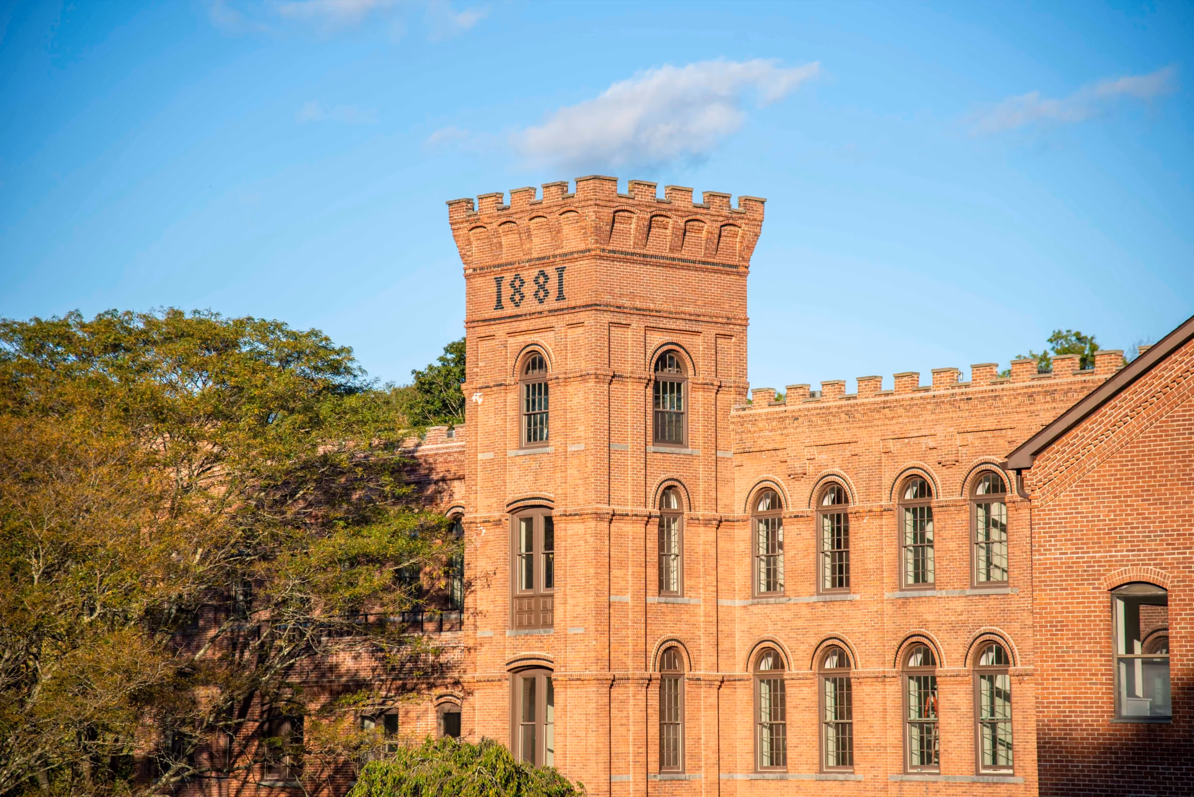 Historic 1881 brick mill tower surrounded by trees