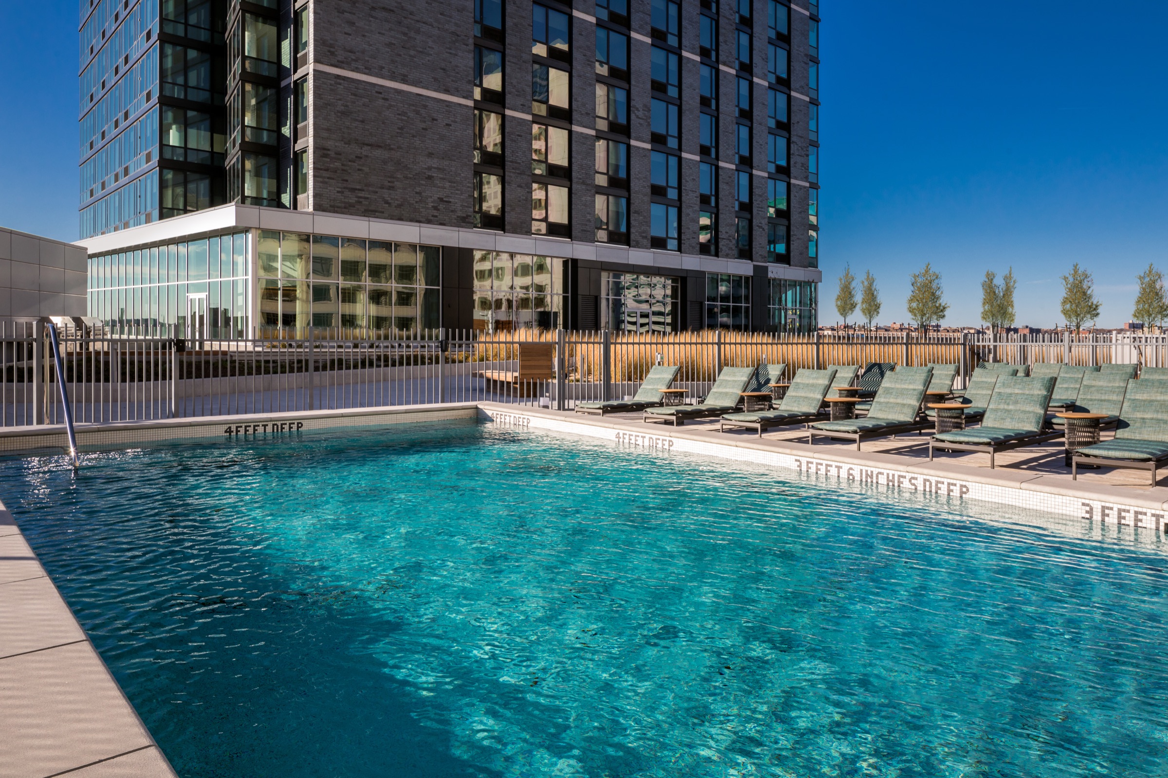 Rooftop pool and lounge deck at a residential tower