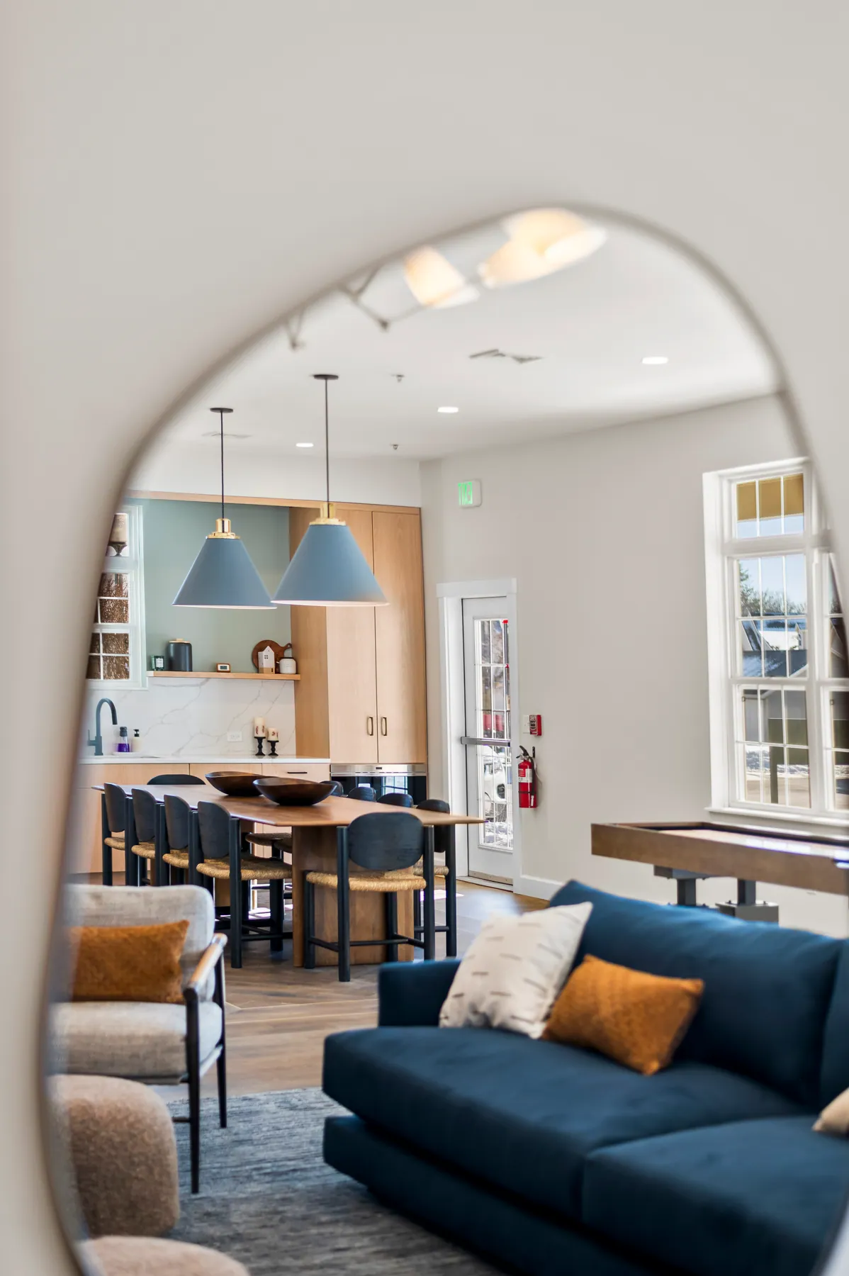 Living room with an arched mirror, navy sofa and open-plan dining