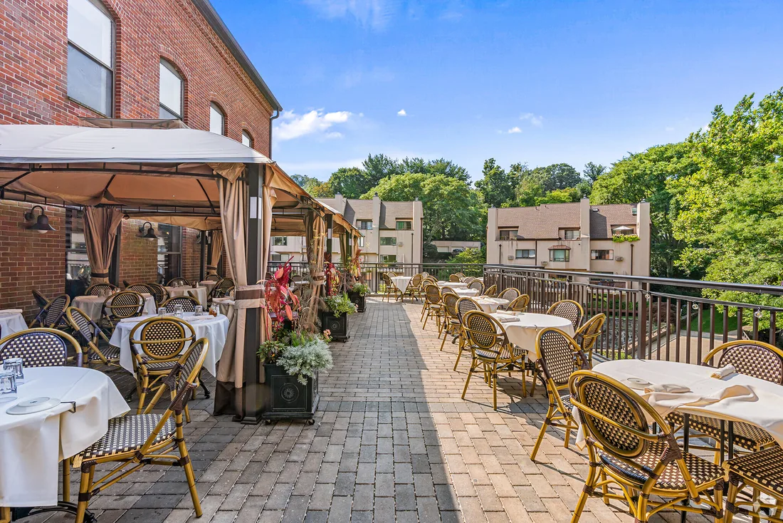 Outdoor terrace with wicker chairs and set tables