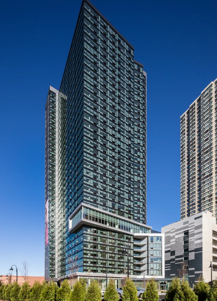 A residential tower developed by Aker against a blue sky