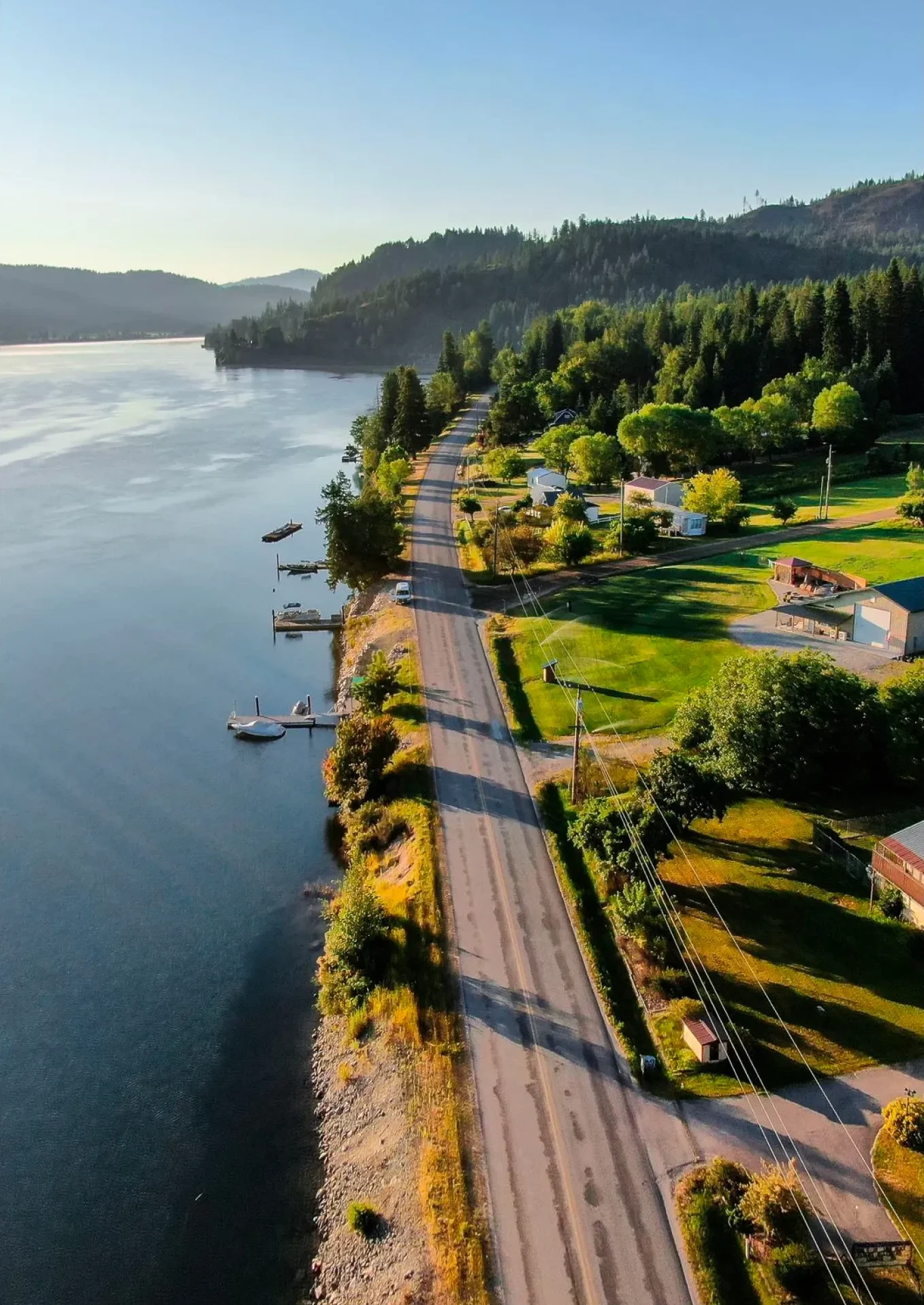 Aerial view of a lakeside road lined with trees