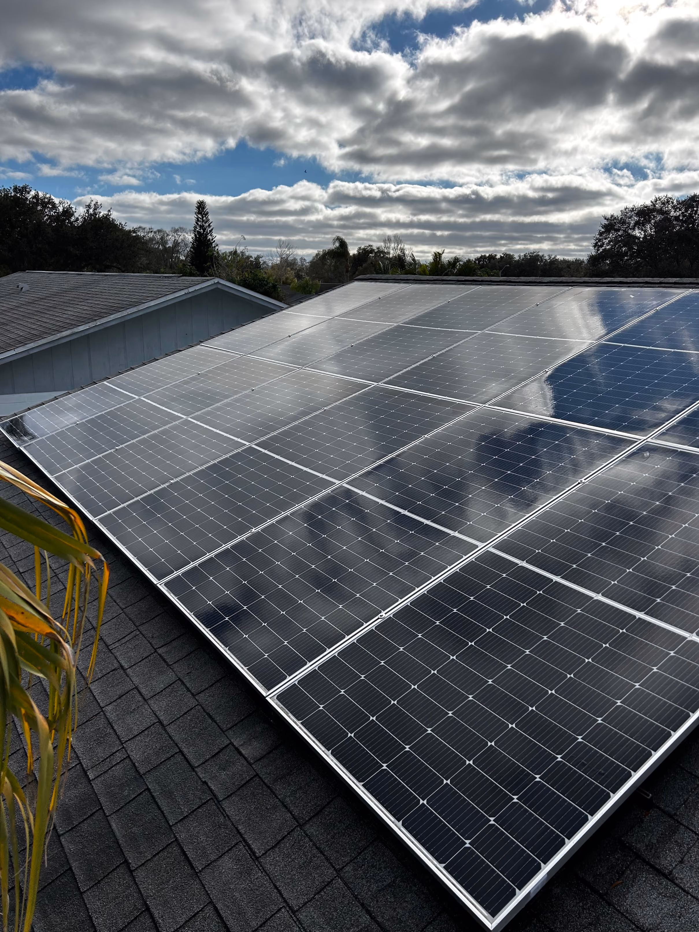 Technician cleaning solar panels on a residential roof in Cape Coral