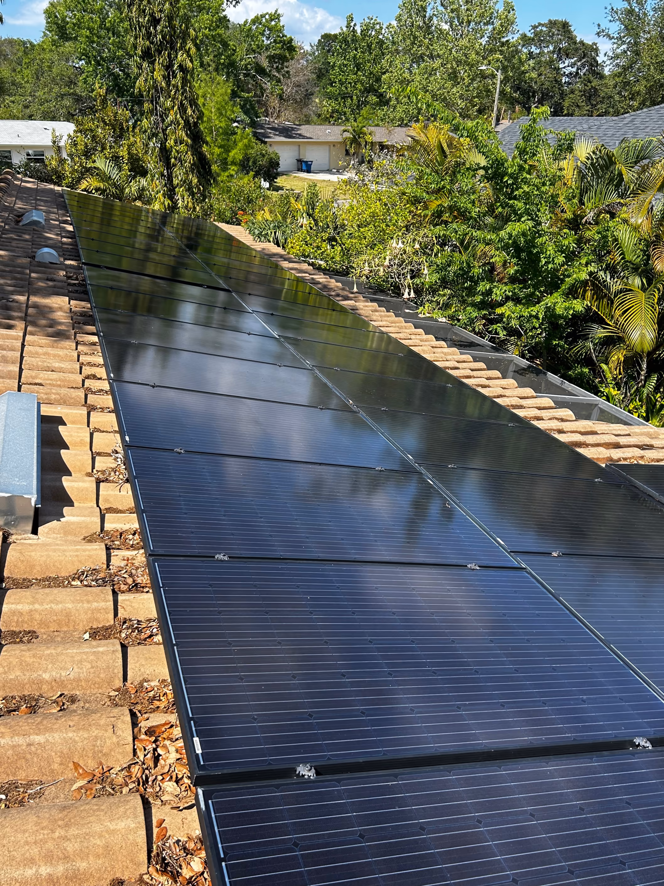 Technician cleaning solar panels on a residential roof in St. Petersburg