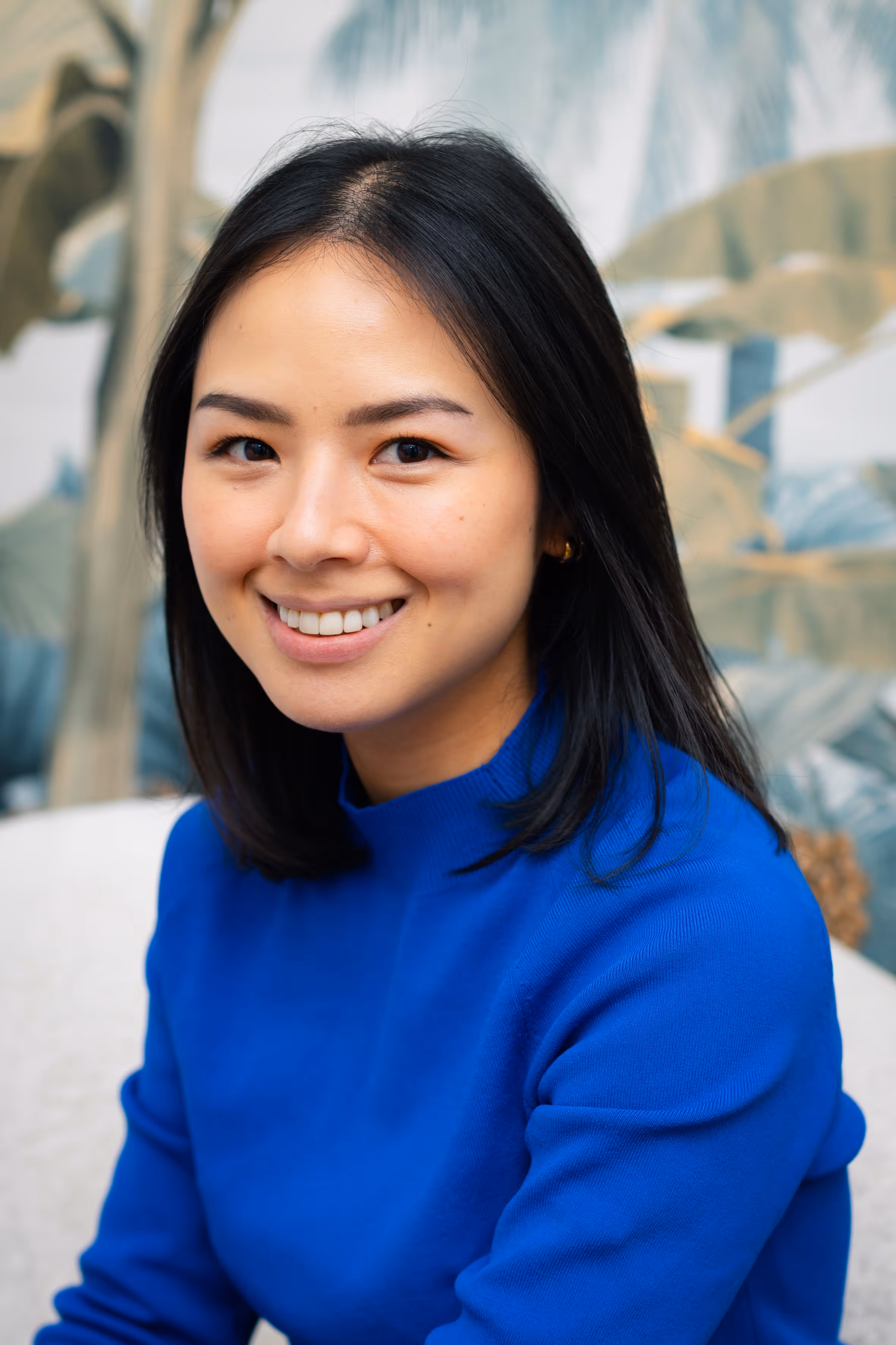 A close-up portrait of a woman smiling.