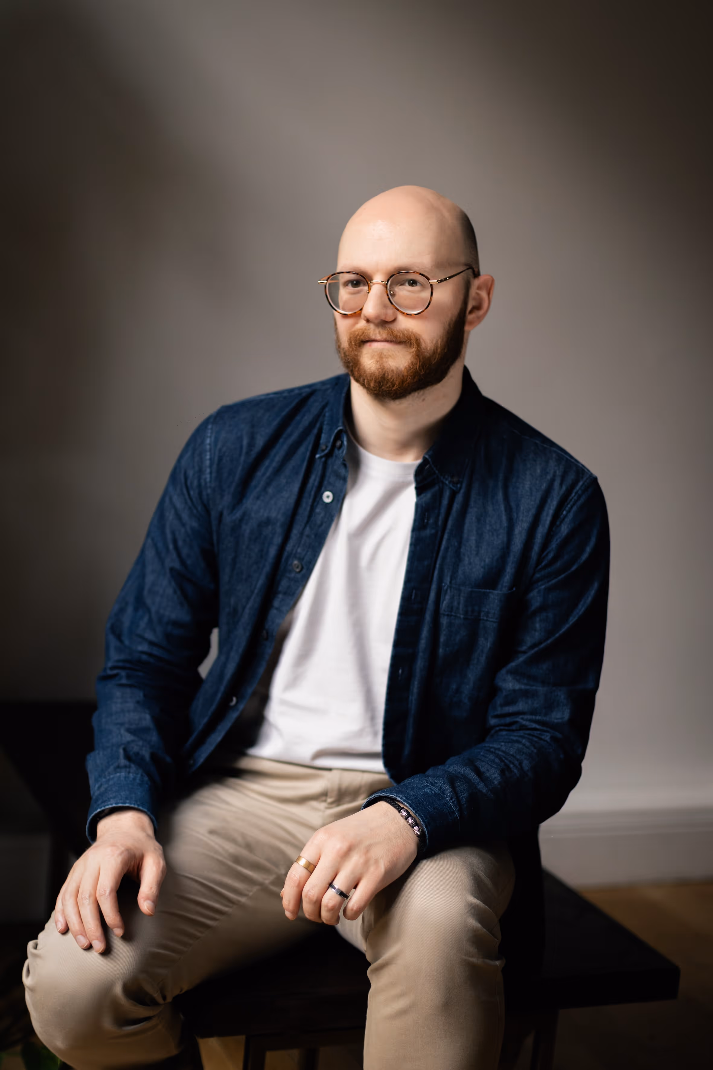 A close-u portrait of a man sitting and smiling.