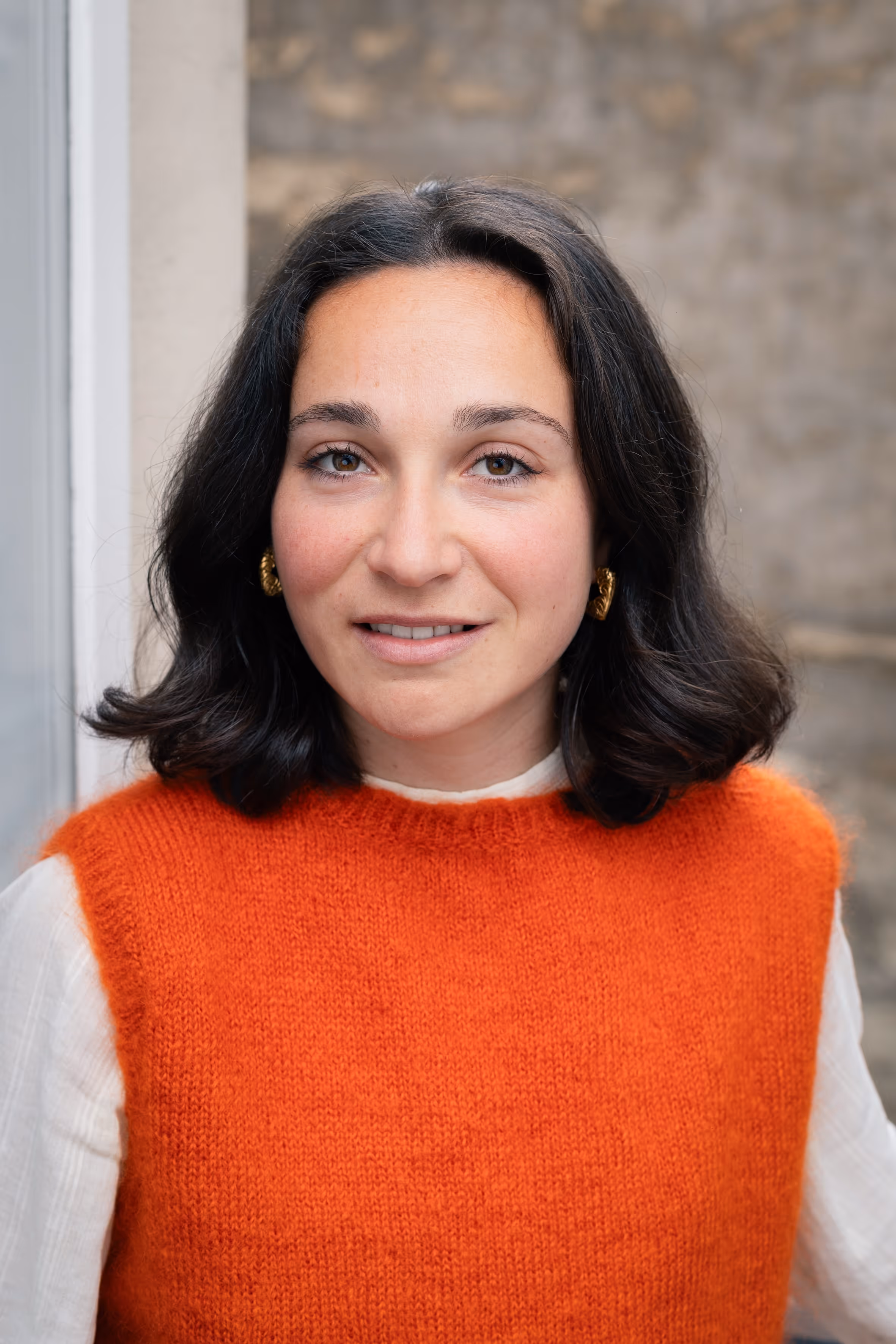 A close-up portrait of a woman with dark hair.