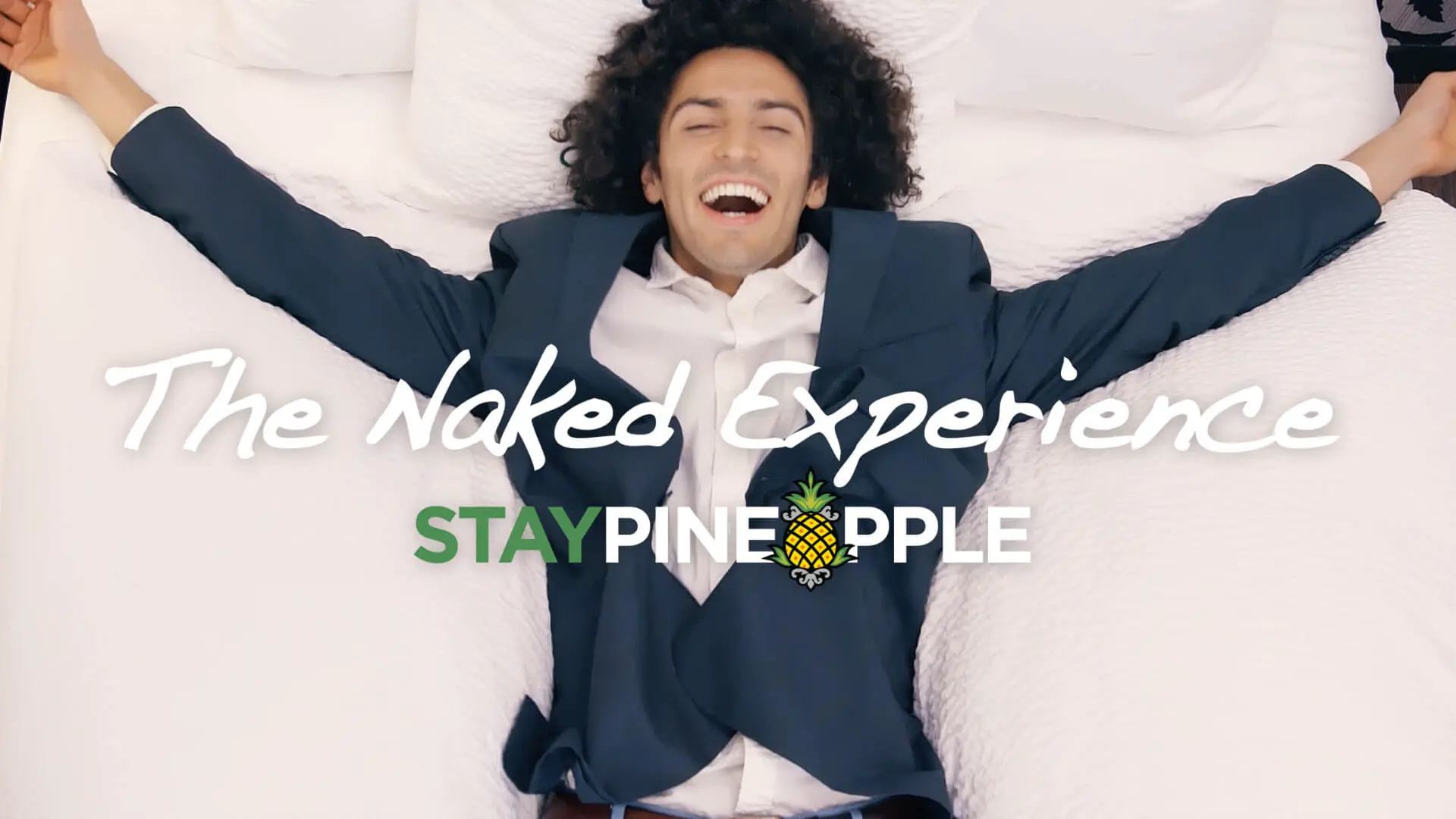 Comedic hotel commercial video for StayPineapple featuring smiling man on bed