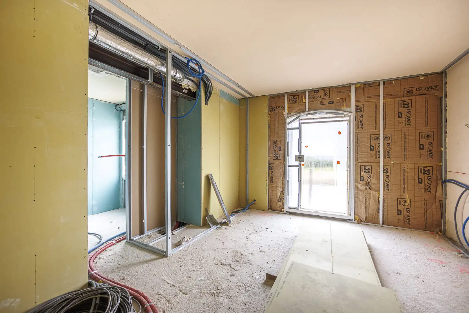 Salle de bain haut de gamme avec baignoire îlot, habillages en marbre veiné, poutres apparentes et vue dégagée sur le paysage.