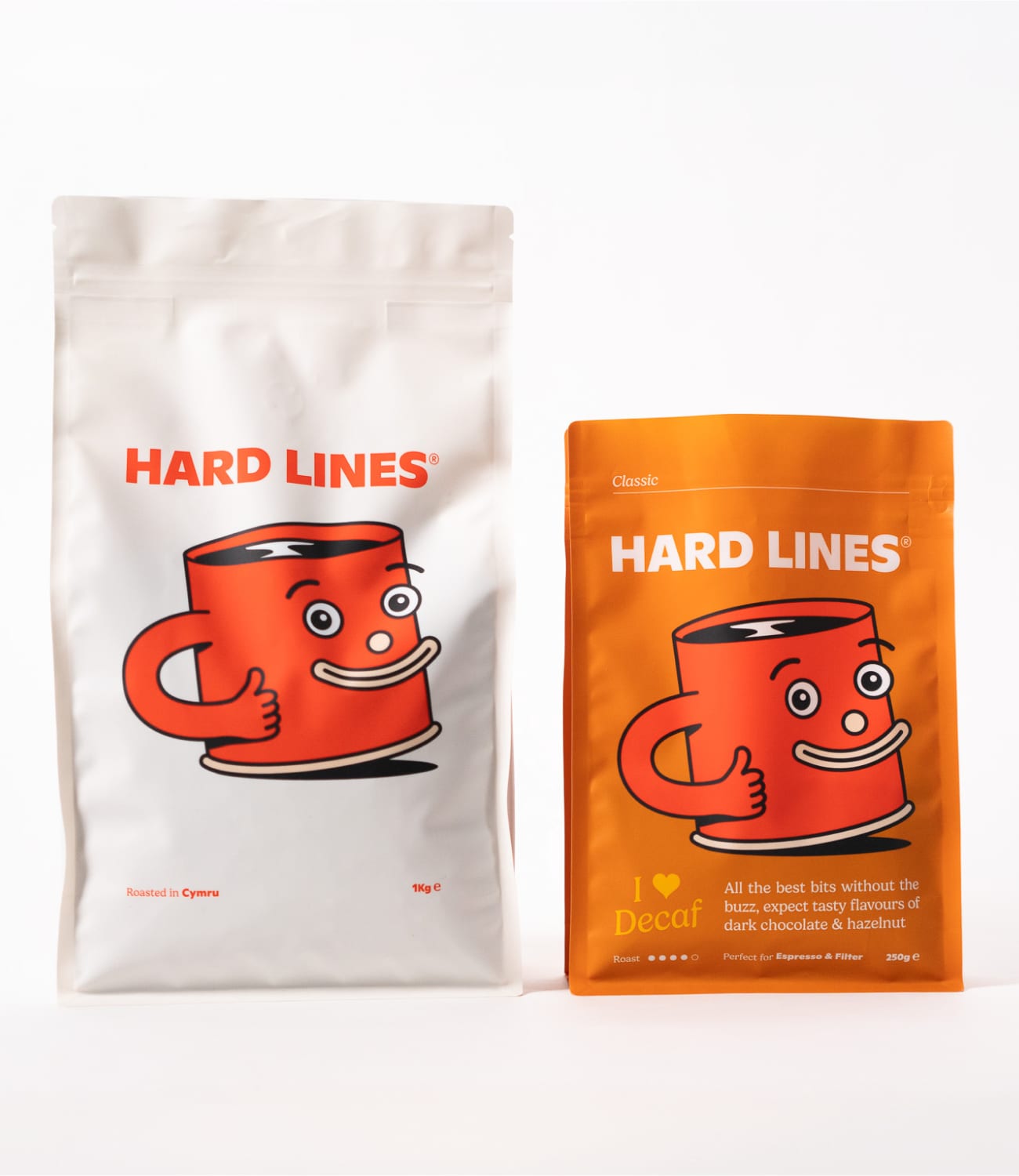 White and orange Hard Lines coffee bags with a smiling mug character