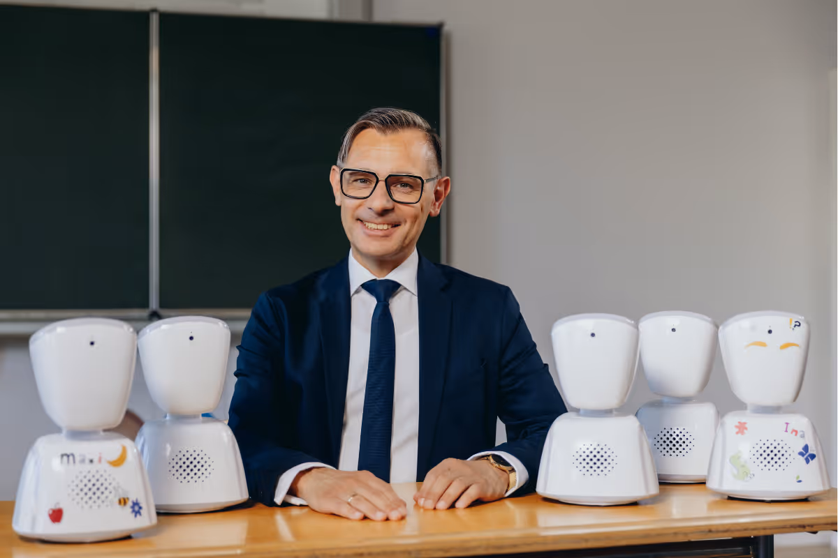 Students from Ladybridge High School, one is sitting on a desk at the front holding his AV1 Robot
