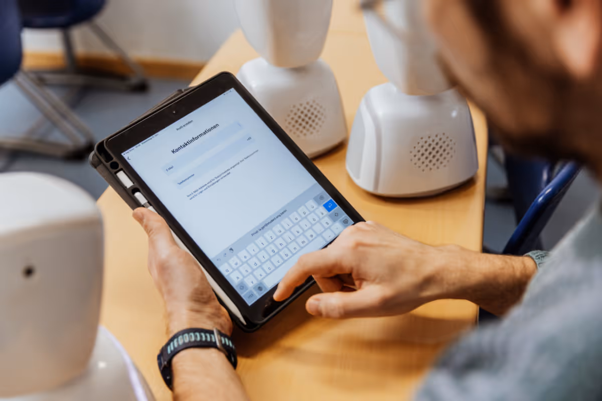 Julie Young vom Somerset Council hält einen AV1-Telepräsenzroboter in der Hand.