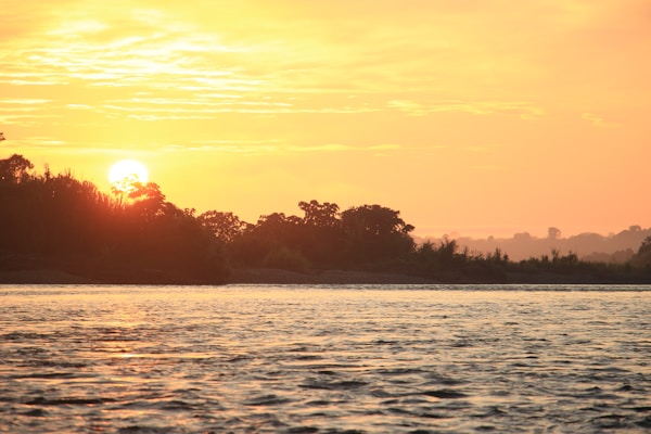 Embrace the serene beauty of dawn with this captivating sunrise over the Rio de Madre de Dios, captured in the heart of the Manu National Park. The early morning sun spills its golden light across the sky, painting a breathtaking canvas of warm hues that reflect on the tranquil waters. As the new day begins in this biodiverse sanctuary, the image evokes a sense of peace and the timeless allure of nature's daily masterpiece.