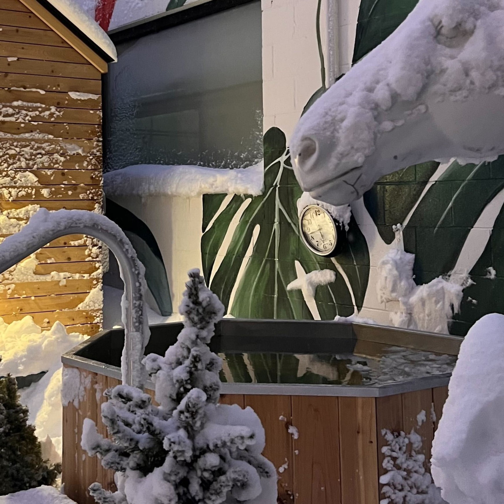 Interior of a wooden sauna with a heater filled with stones and wooden benches along the wall.