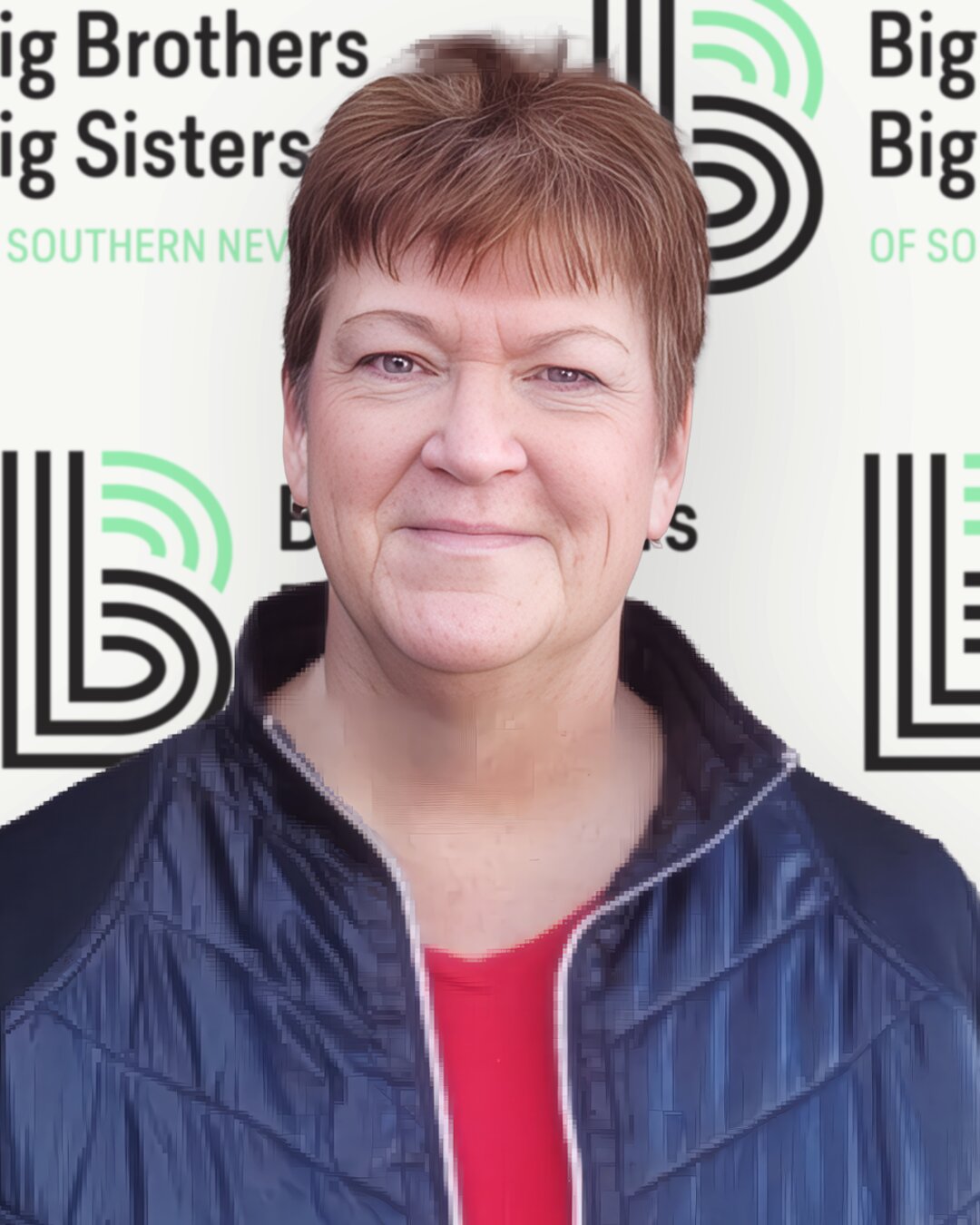 Woman with short, brunette hair wearing a red shirt and black jacket 