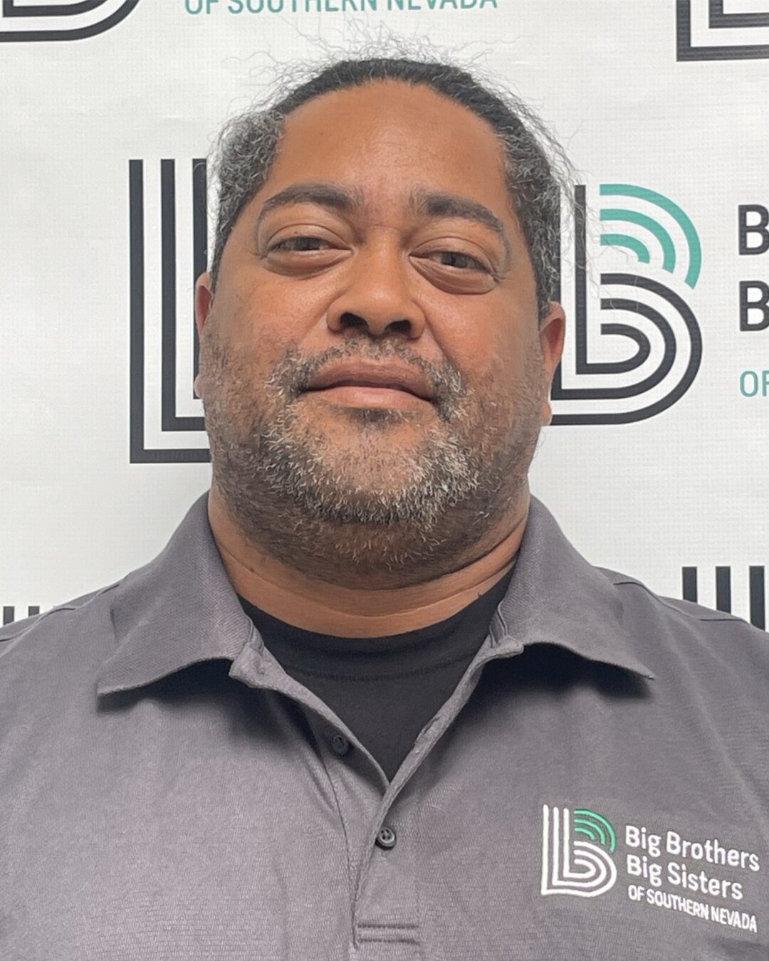 Earl David, Donation Center Driver, smiling and wearing a grey Big Brothers Big Sisters polo