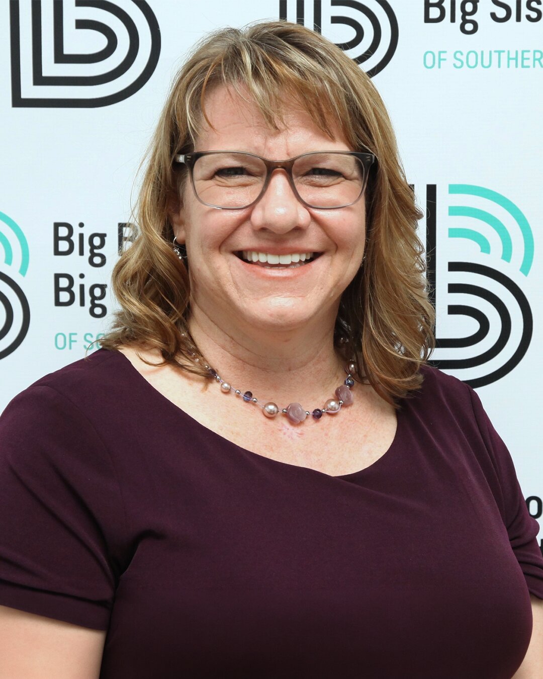 Kristy Froehlich, Vice President of Operations, smiling while wearing a purple shirt and necklace