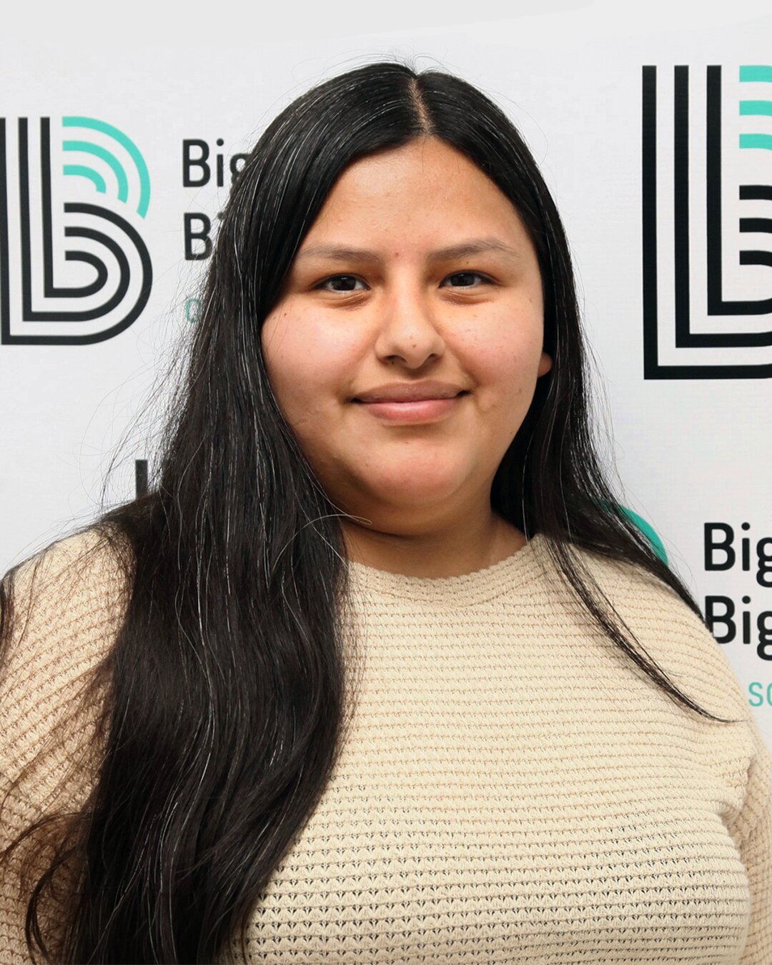 Mayra Sanchez, Donation Center Driver Manager, smiling and wearing a cream sweater