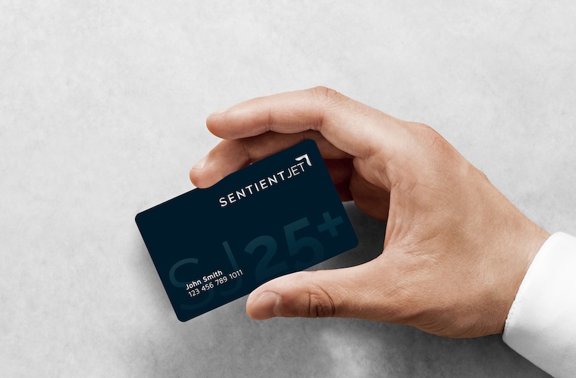 Hand holding a Sentient Jet 25th anniversary jet card
