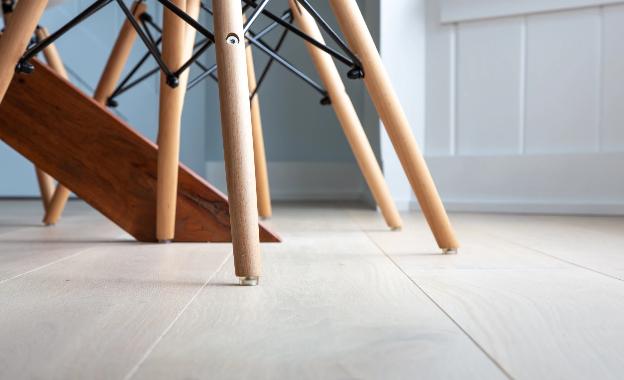 A pair of wooden legs on a white wooden floor, showcasing quality craftsmanship and durability.
