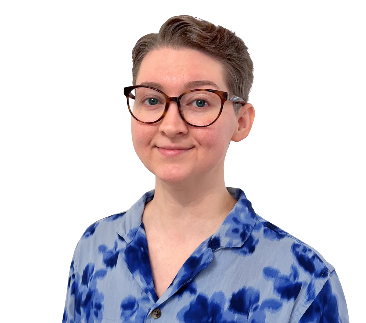 Kier Wise-Baker smiling. They are a white adult with light brown hair, glasses, and a blue floral button up.