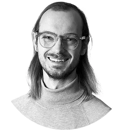 Hymyilevä nainen, jolla on vaaleat hiukset sidottuina taaksepäin, yllään laivastonsininen bleiseri ja raidallinen paita.