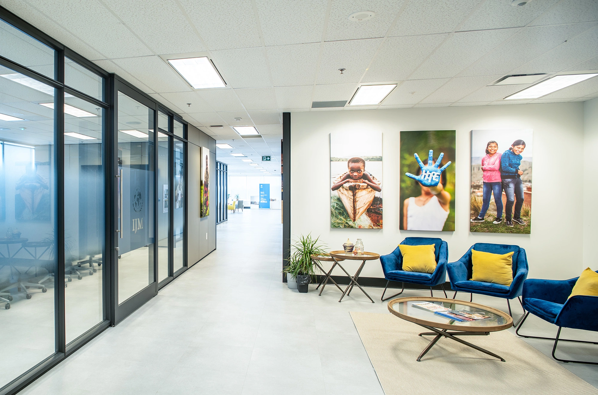 IJM lobby area with glass doors leading into boardroom, colourful paintings and armchairs in seating area