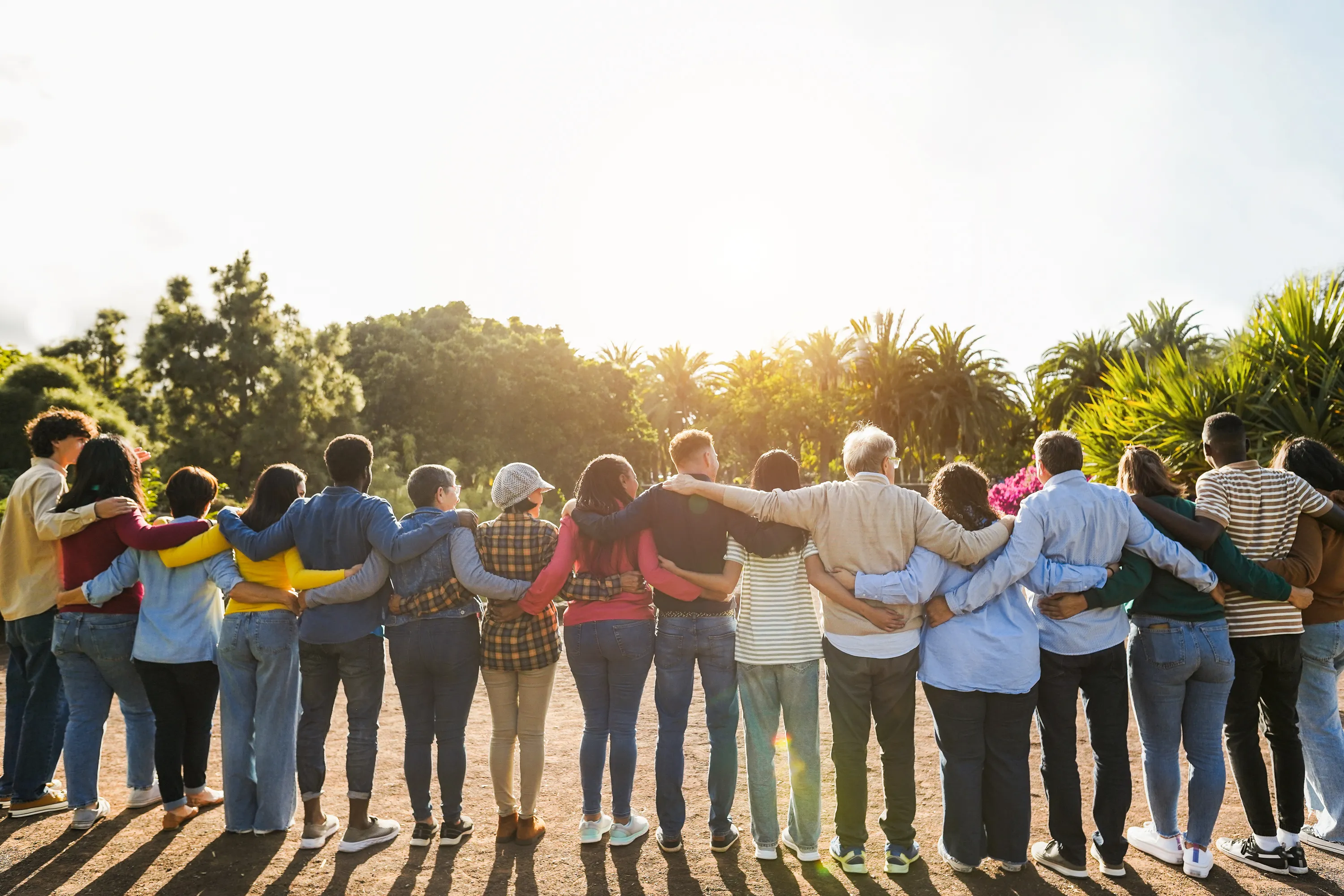A large group of people standing arm in arm with their backs to the camera - The Fellowship Images