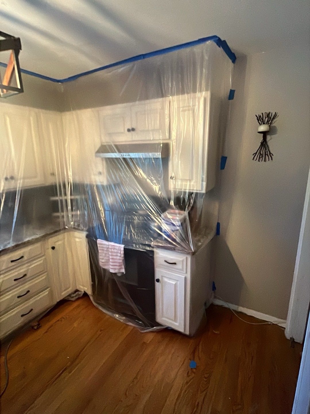 Kitchen cabinets, hood and range sealed in plastic to protect them during water damage work