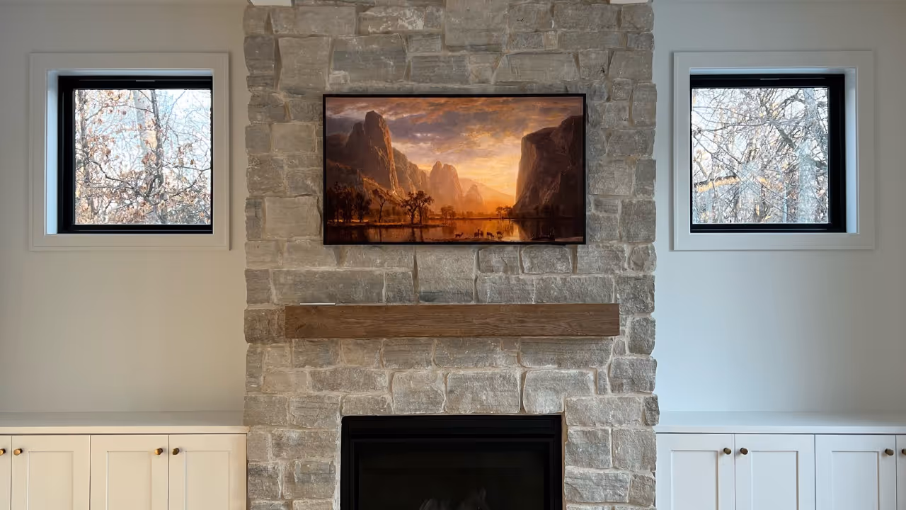 The frame by Samsung mounted onto stone fireplace.