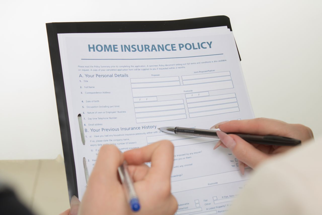 A close-up view of a Home Insurance Policy document alongside a magnifying glass, representing the process of shopping and comparing Florida homeowners insurance rates by county.