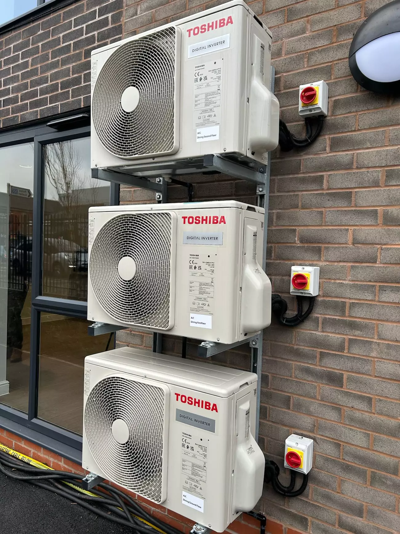 Three Toshiba air conditioning units outside of building.