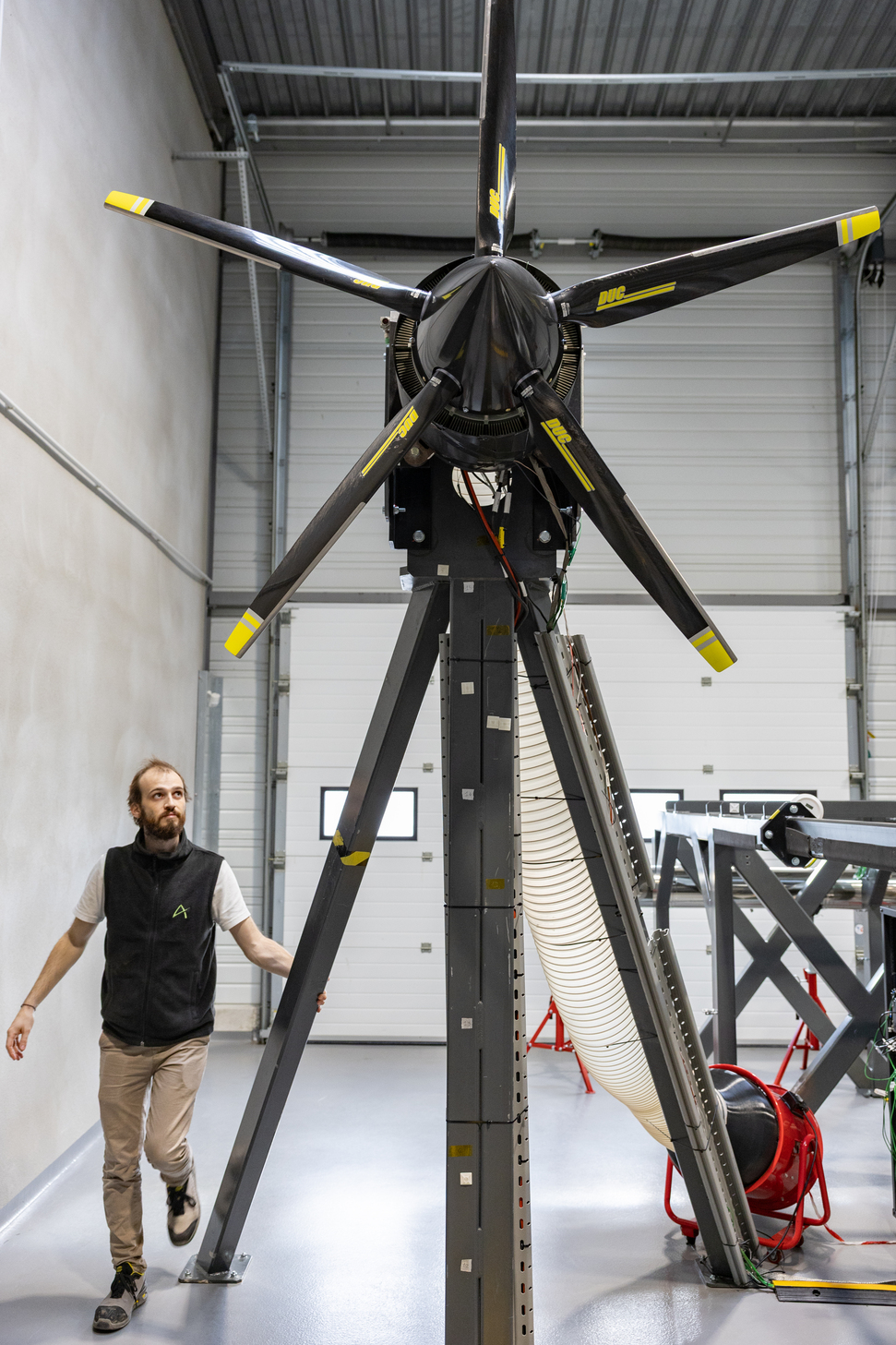 Ascendance engineer next to a rotor test rig in the company test facility