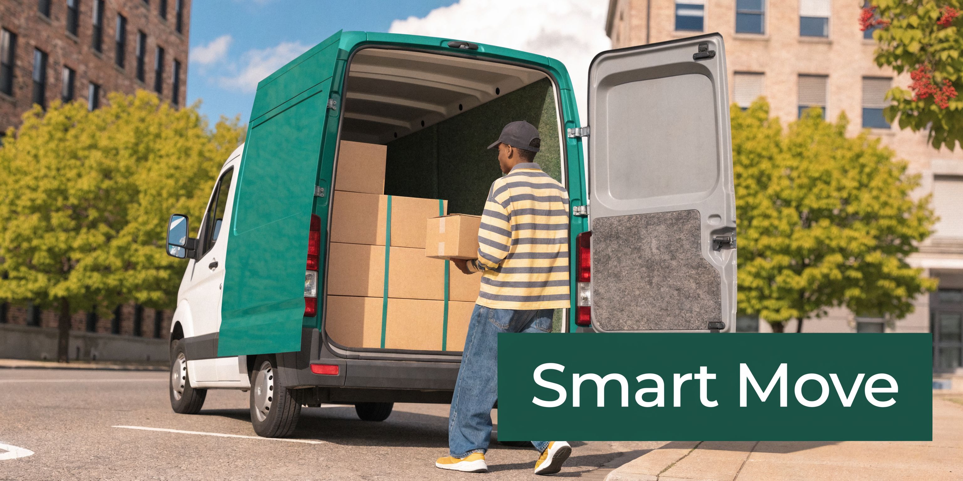 A delivery person loading a brown cardboard box into the back of an open green cargo van.