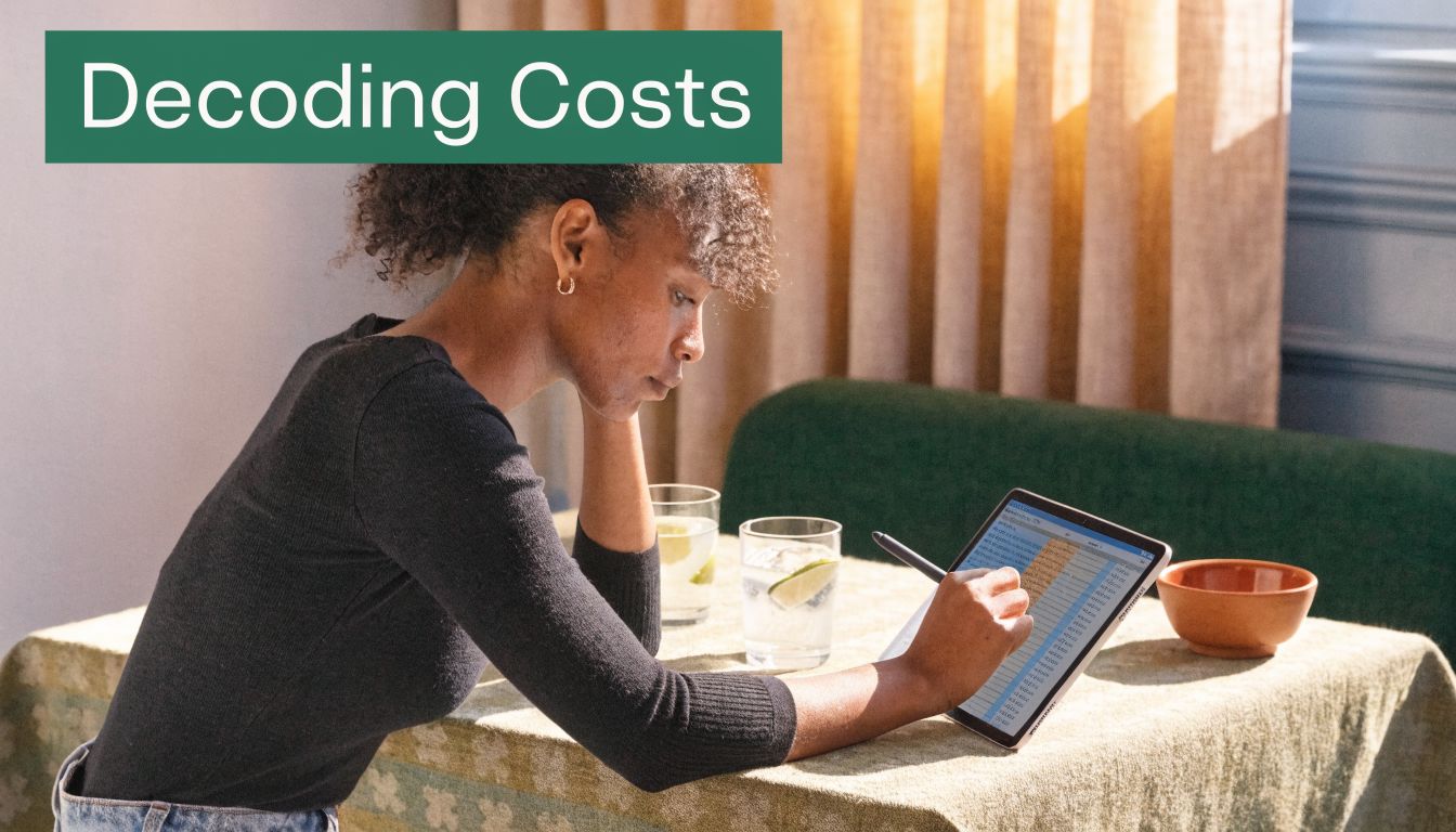 A young woman sitting at a table using a digital tablet with a stylus to review financial data.