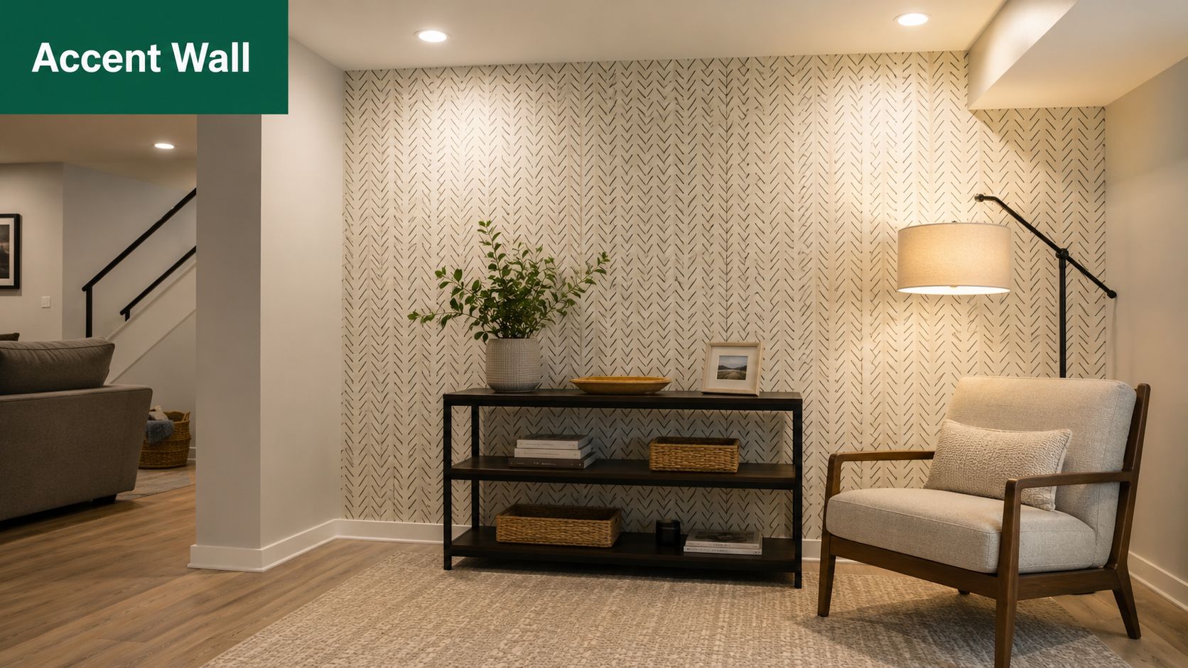 A modern basement corner featuring a decorative patterned accent wall, console table, and comfortable armchair.