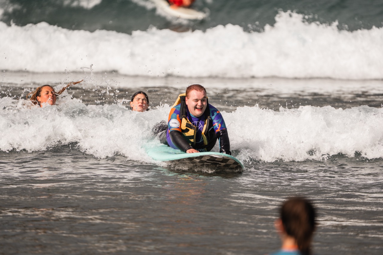 Surfer smiling while riding wave on belly