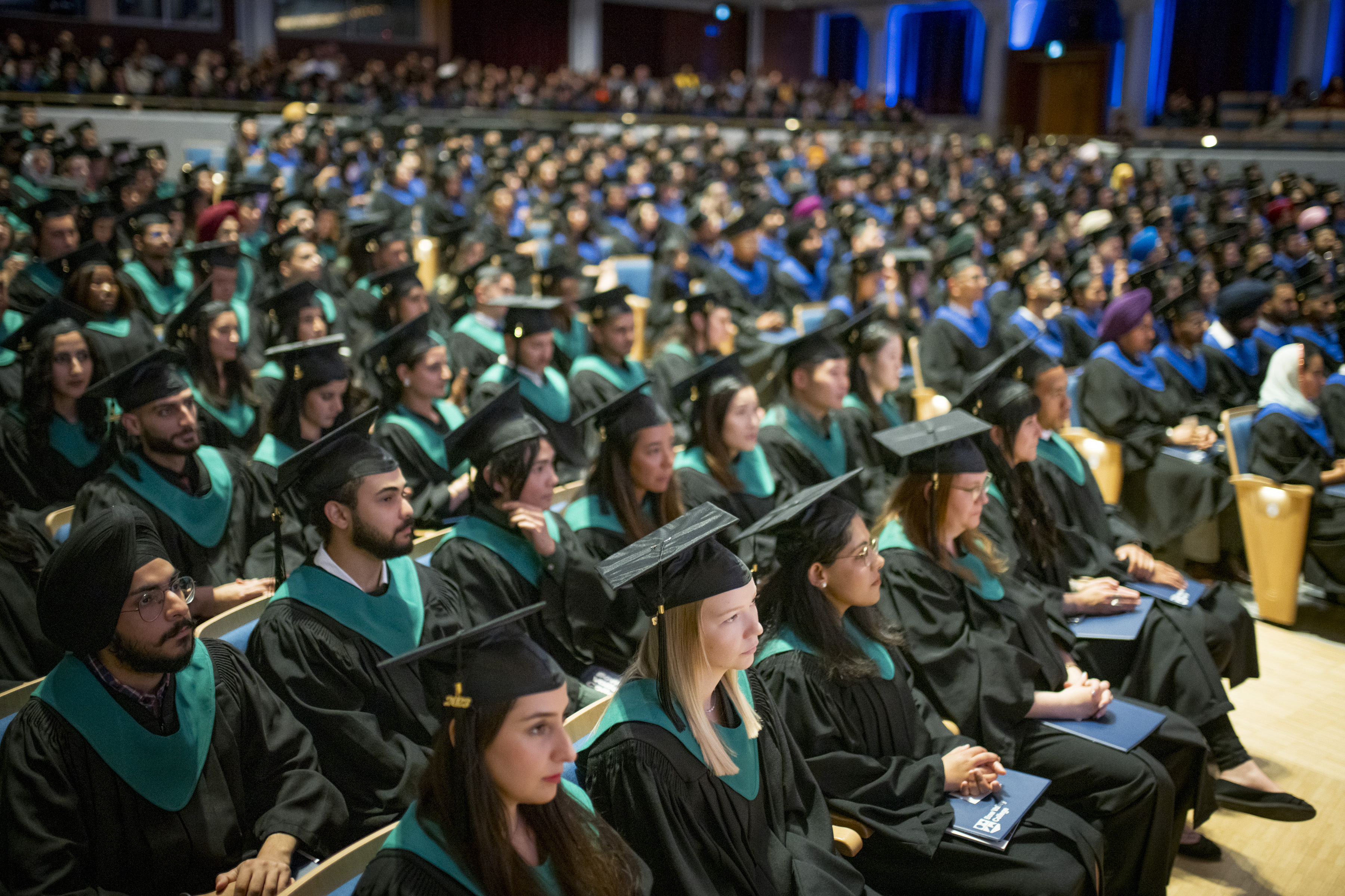 Bow Valley College graduates sitting at the Arts Commons auditorium. 