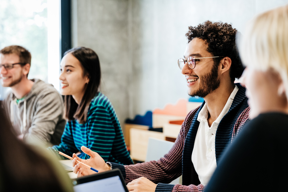 A group of students smiling as they learn.