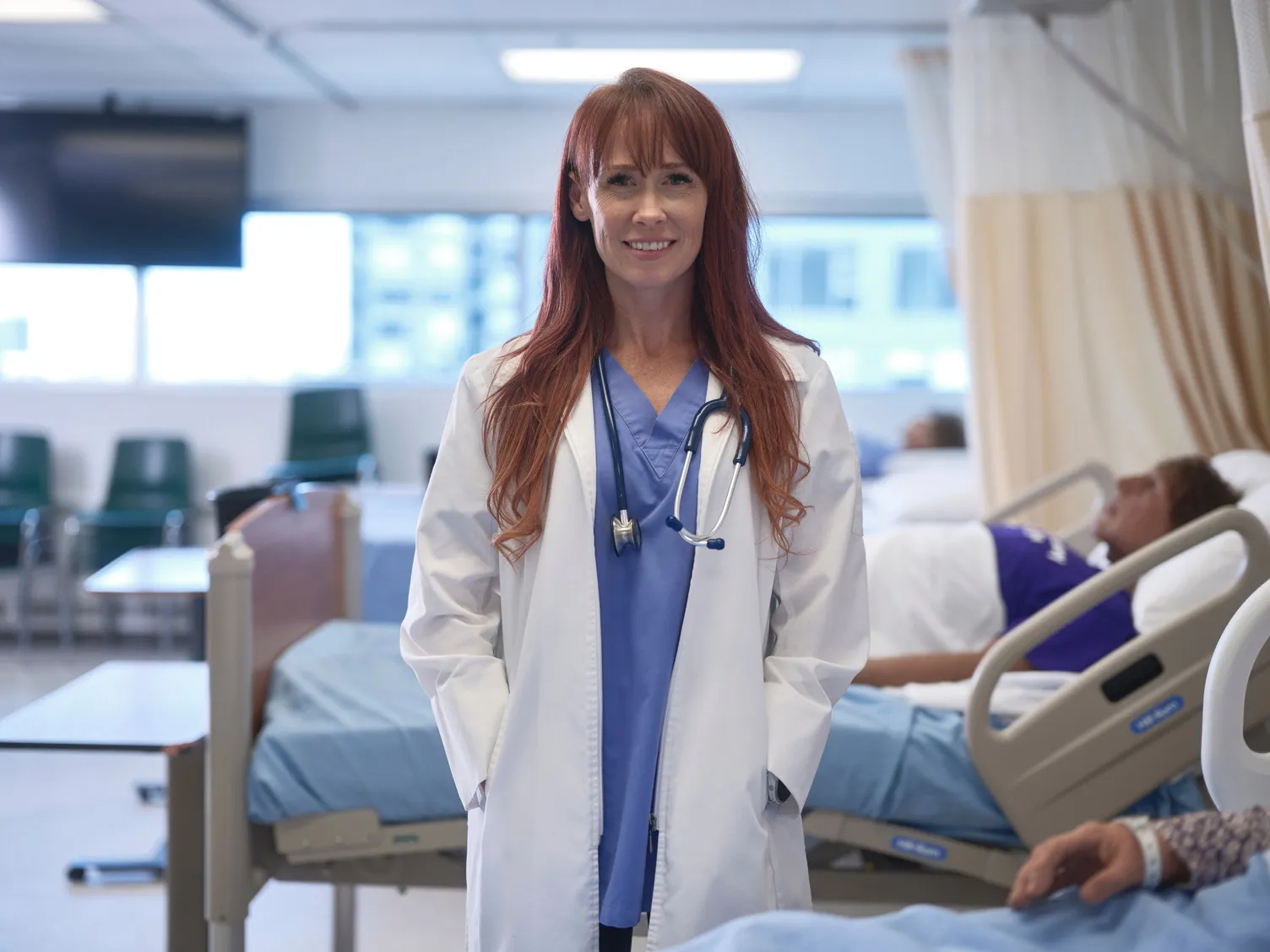 A nursing instructor smiling proudly at the camera