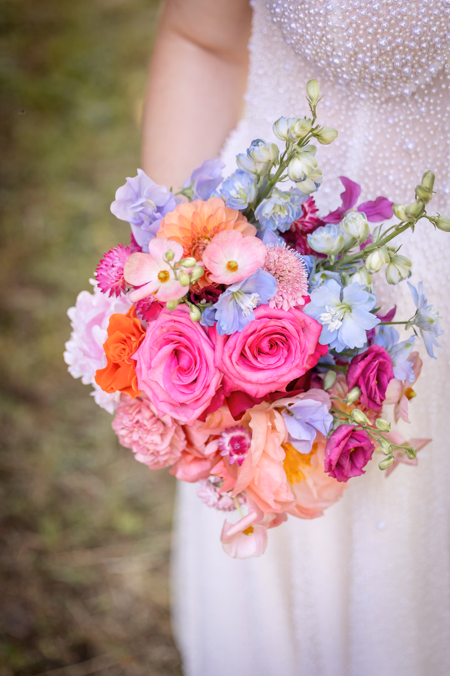 Bunter Brautstrauß mit Rosen, Pfingstrosen, Nelken und anderen Pastellblumen in zarten Farben.