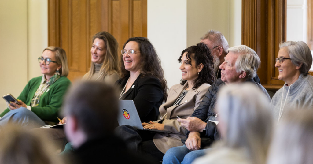 Audience members smiling up at a presenter