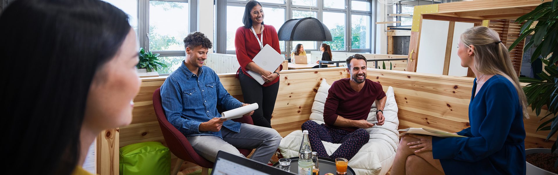 Group of colleagues talking in an informal office seating area