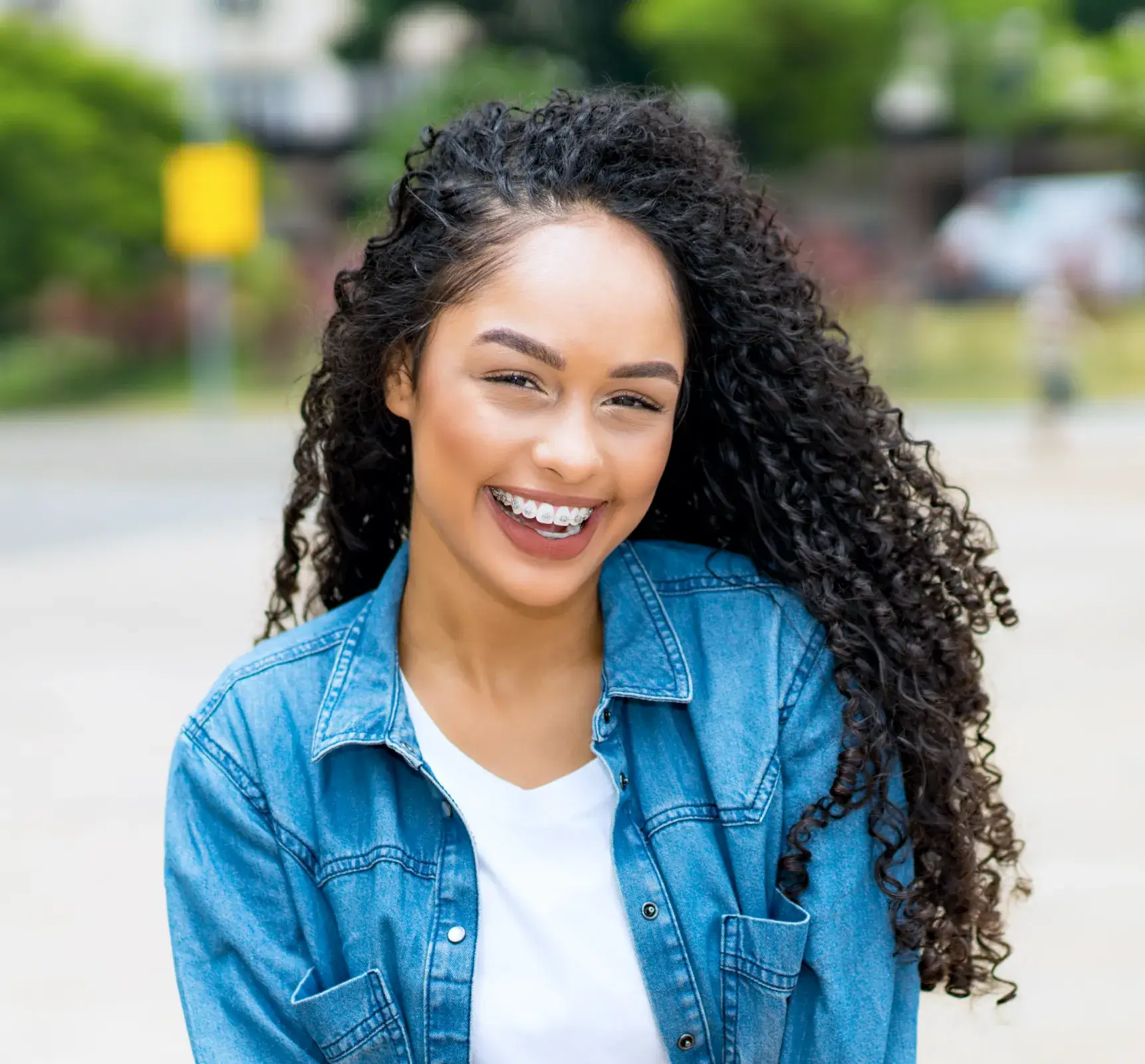 a woman with curly hair smiling at the camera