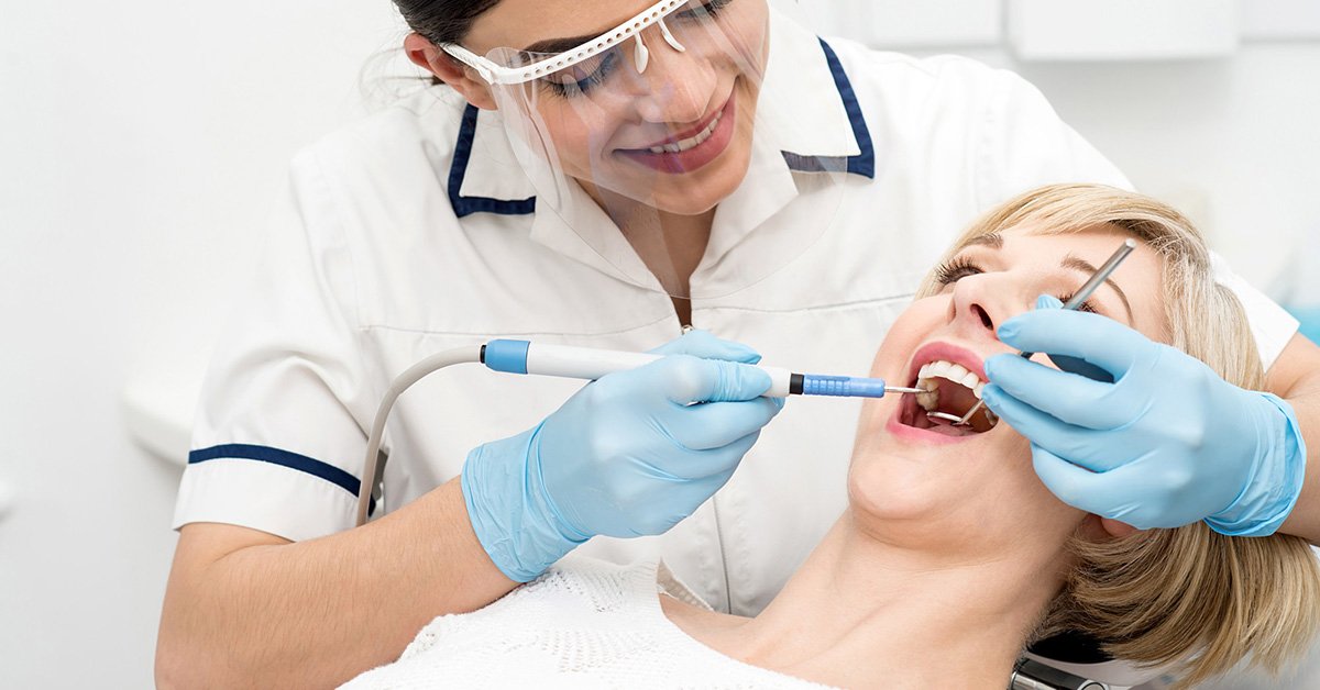 Dental hygienist performing a cleaning with professional tools