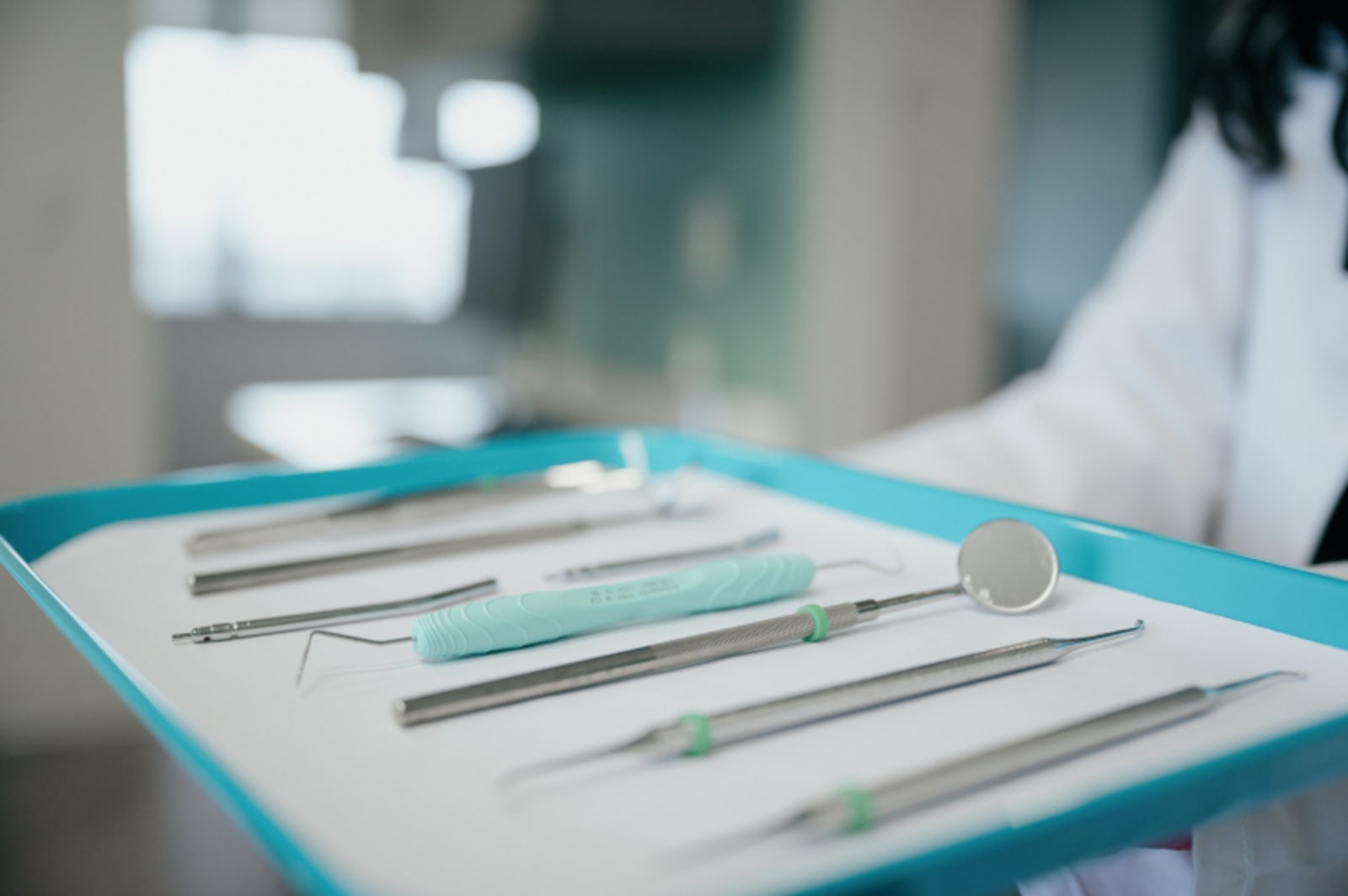 Dental instruments arranged on a tray with turquoise tray liner