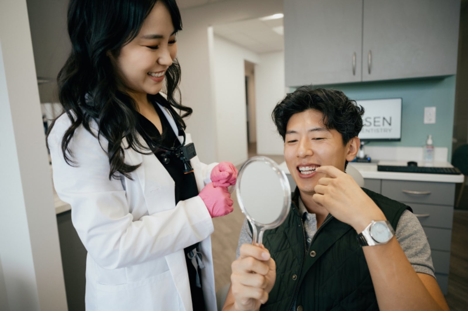 Female dentist in white coat discussing treatment options with patient in clinical setting