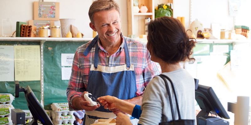 Woman paying for groceries at a small business 