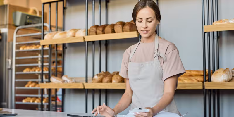 Small business owner assessing fast business loan options in her bakery
