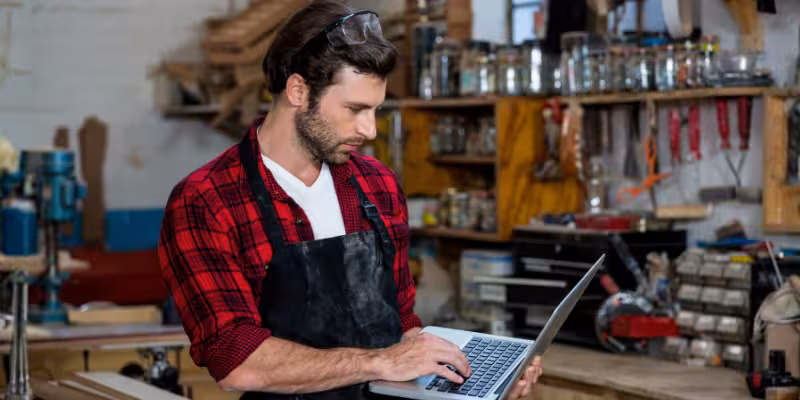 Small business owner in workshop changing ATO credit card payment on computer
